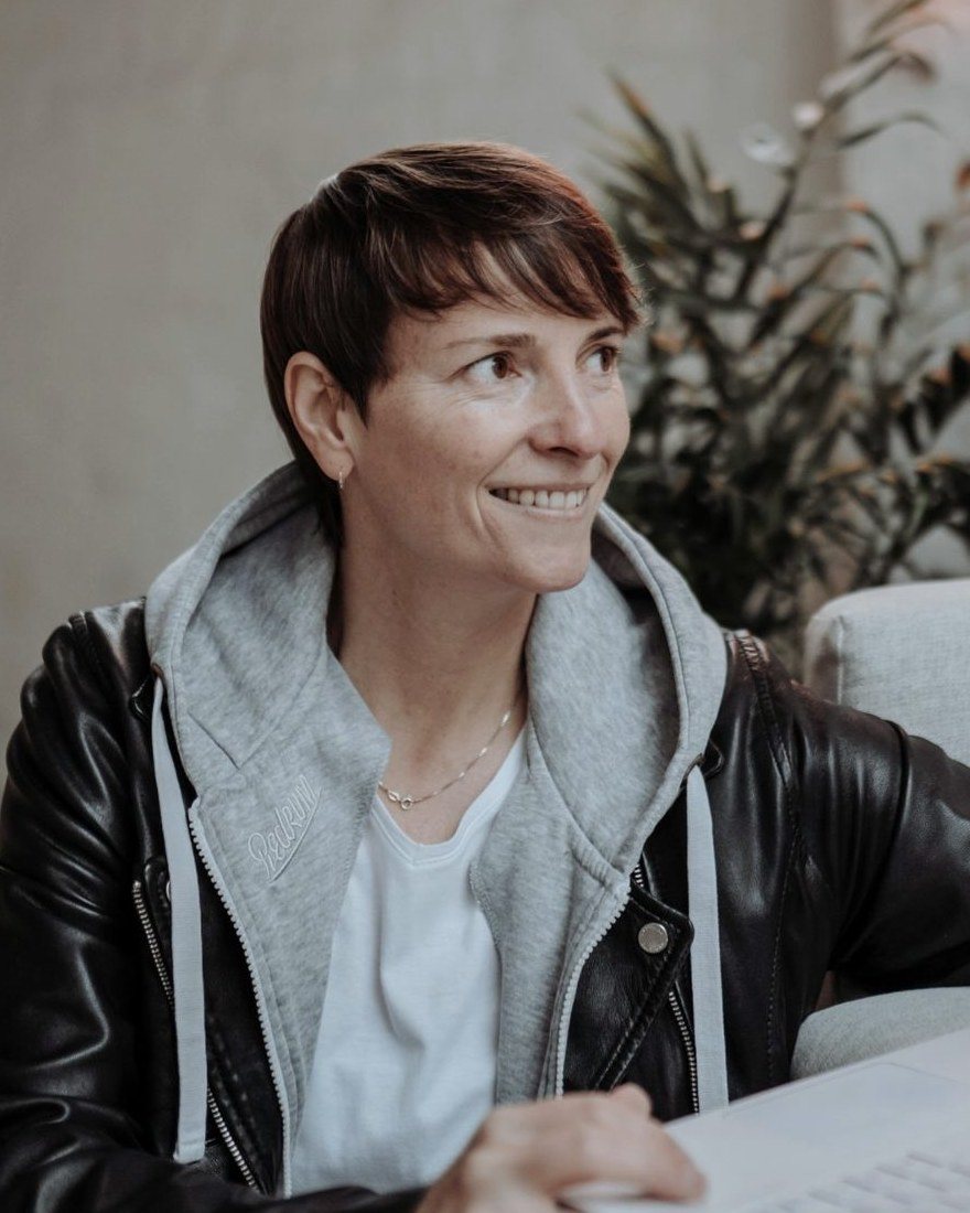 Porträt von Alexandra Sackmann, lächelnd mit Laptop